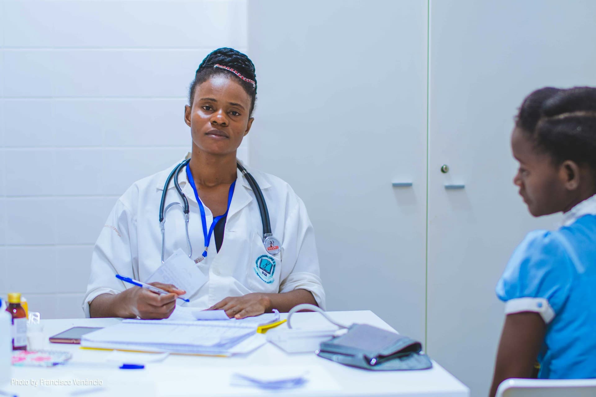Nigerian female doctor consulting with a young patient at a clinic